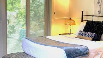 A bedroom with a bed, a bedside lamp, and a view through a window.
