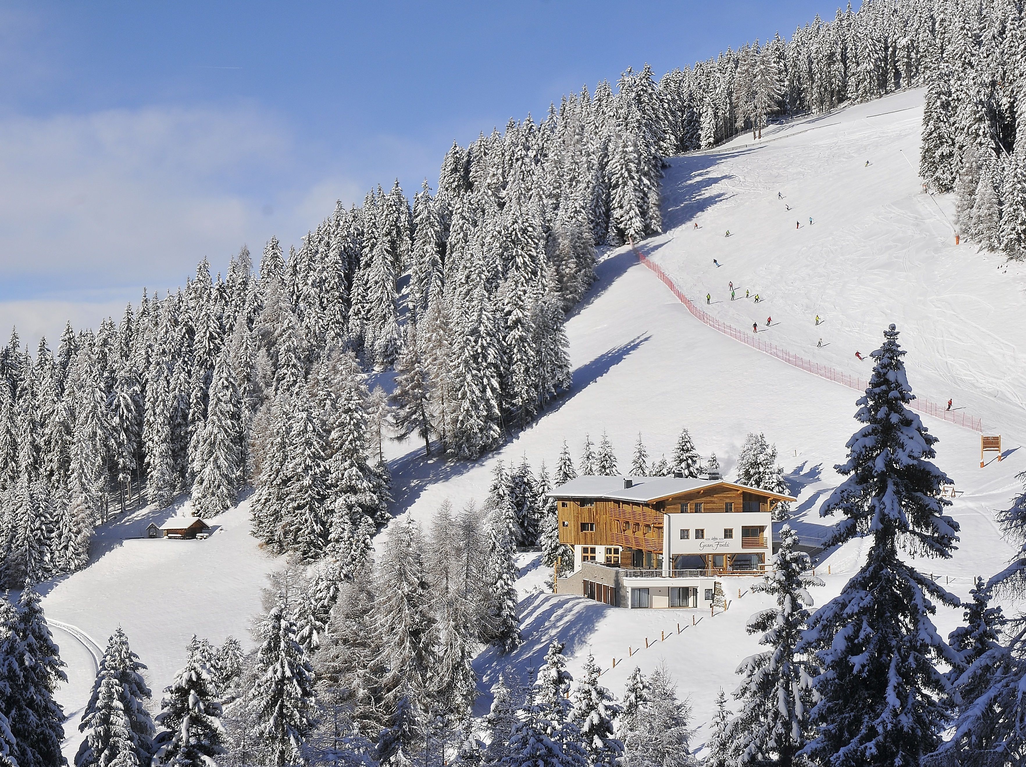 Montanha coberta de neve com uma hospedaria e pistas de esqui.