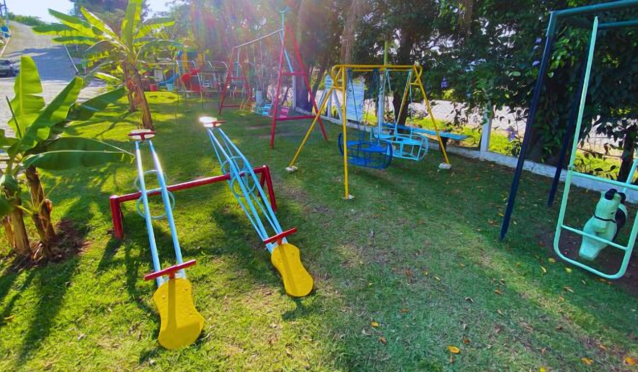 Une aire de jeux avec des balançoires et une structure d’escalade.