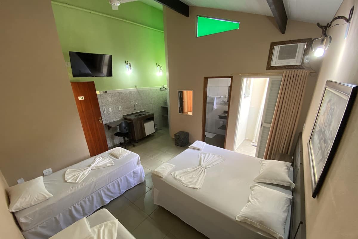 Ett hotellrum med två sängar, ett skrivbord, en spegel och en tv.