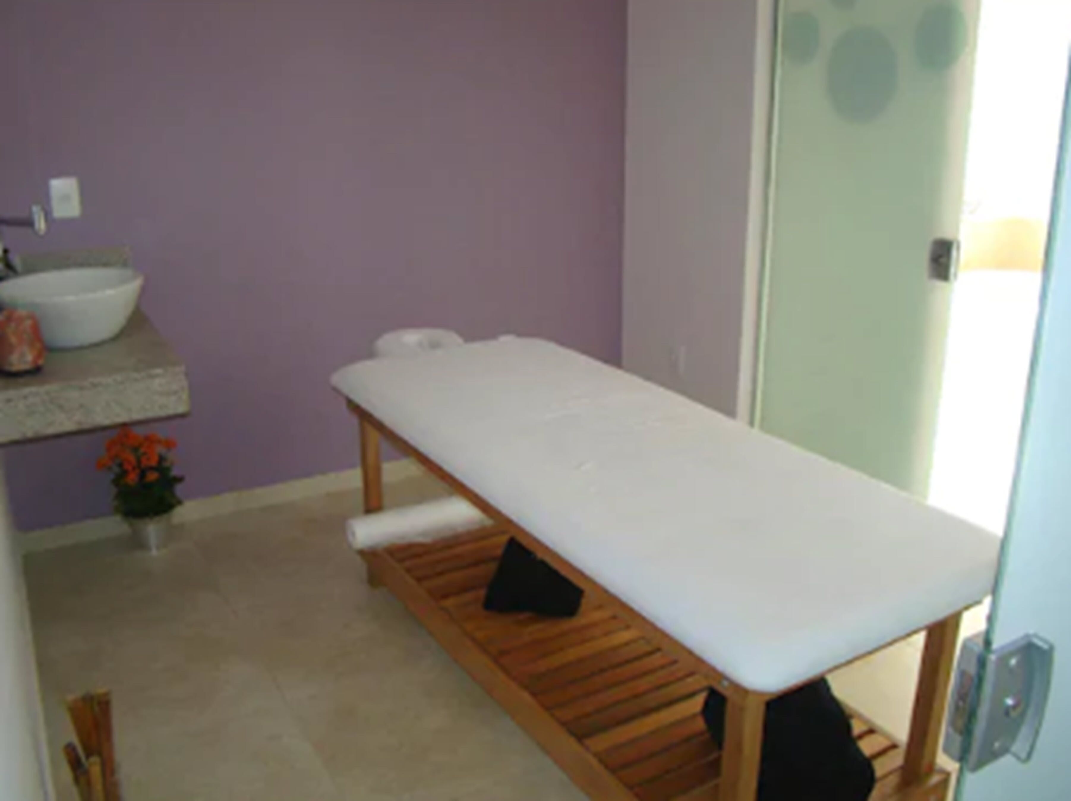 Une salle de bain avec un banc en bois, un lavabo et un miroir.
