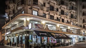 Un hotel de varios pisos con restaurante en la planta baja y terraza.
