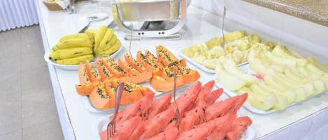 Un buffet con diversi tipi di frutta e dolci.