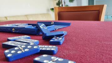 Una mesa con fichas de dominó azules esparcidas sobre un mantel rojo.