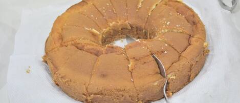 A round cake with a knife in it, placed on a white paper.