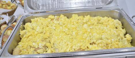 A buffet with scrambled eggs and other dishes.