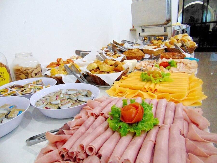 Un bufé con diversos alimentos, incluyendo carnes, quesos y pasteles.