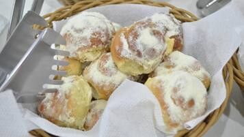 Uma cesta com doces e um pegador de pastelaria.