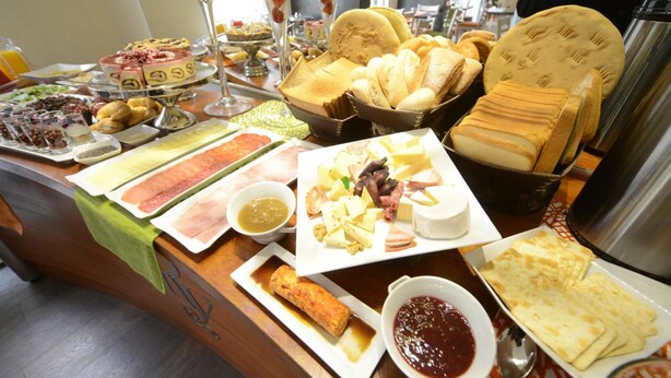 A buffet with various food items including pastries, cheeses, and meats. - Hotel Boutique Reyall (Santiago)