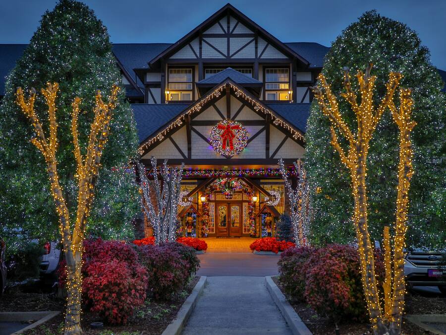 A hotel with a traditional Tudor-style architecture, featuring a prominent entrance with a decorative archway and a large wreath above the doors.