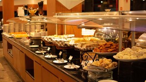 A buffet with various food items and serving utensils. - Hotel Golden Park Internacional Foz & Convenções By Nacional Inn (Foz do Iguaçu)