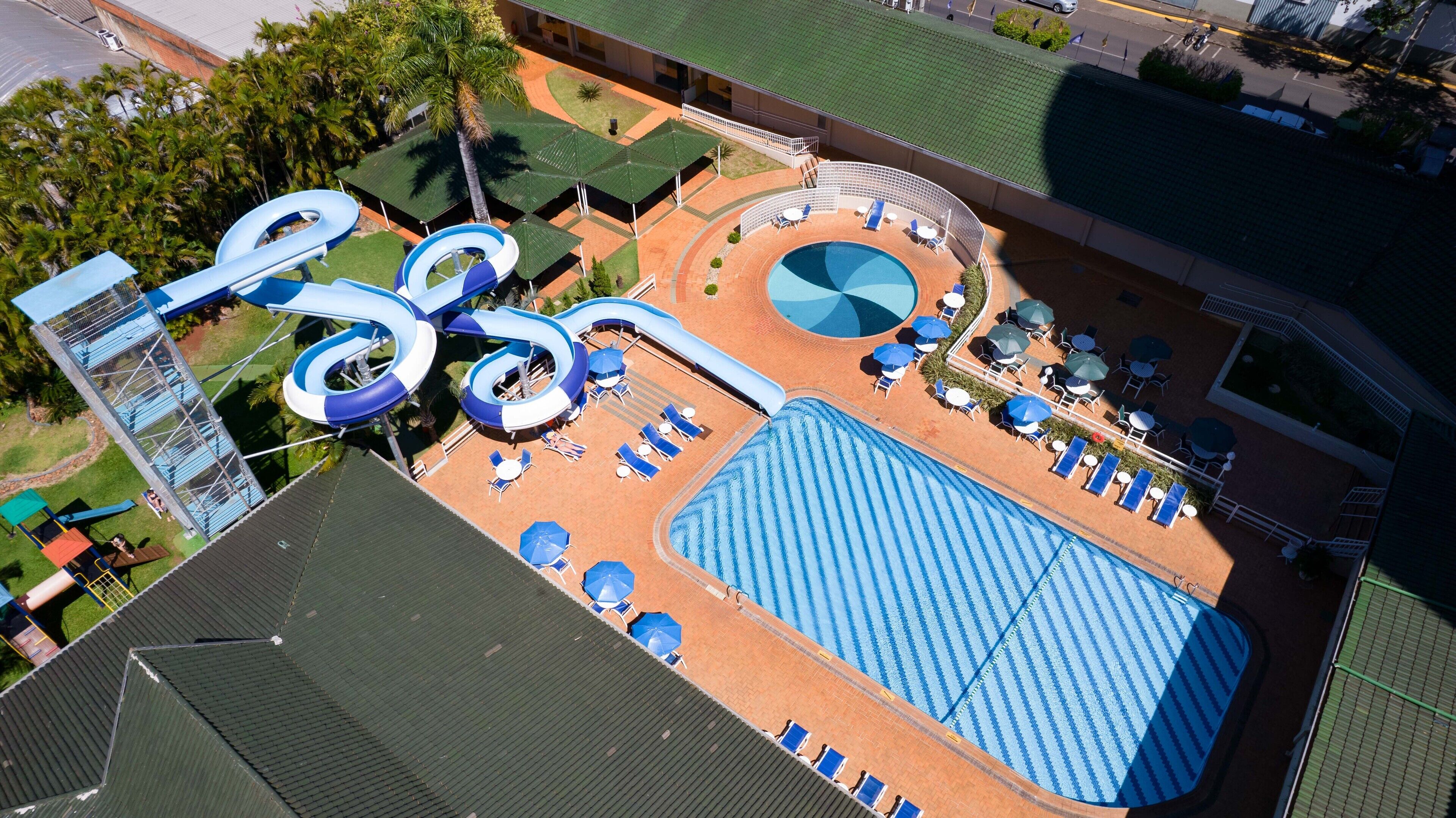 A water park with a large pool, slides, and sun loungers.