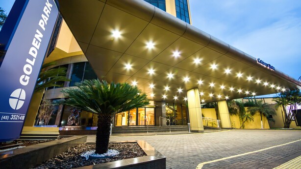 The exterior of the Golden Park hotel with a prominent entrance, a large sign, and a well-lit canopy. - Hotel Golden Park Internacional Foz & Convenções By Nacional Inn (Foz do Iguaçu)
