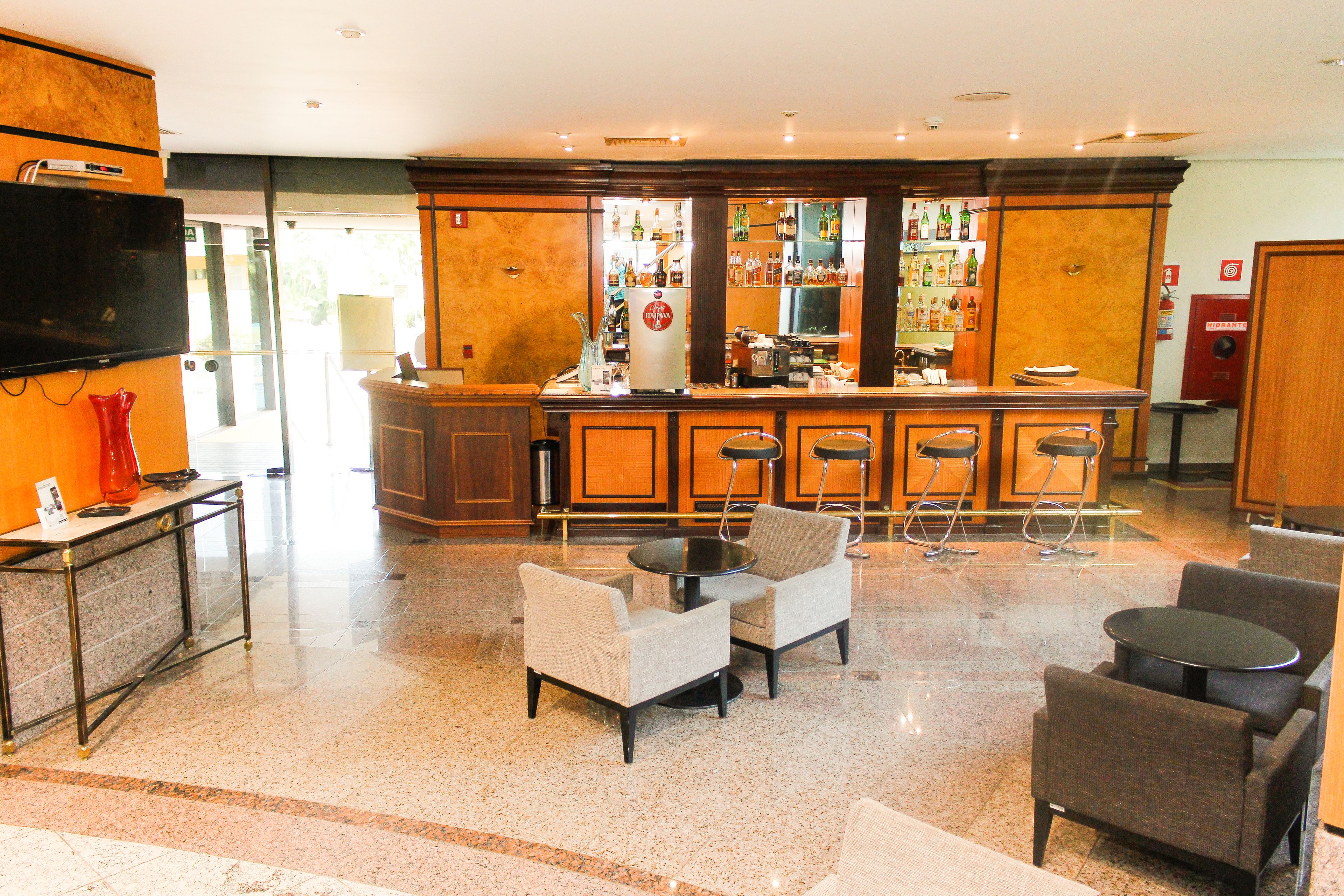 A lobby with a bar area, seating, and a television.