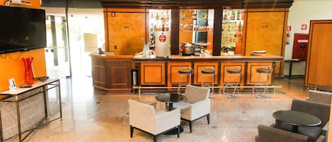 A lobby with a bar area, seating, and a television.