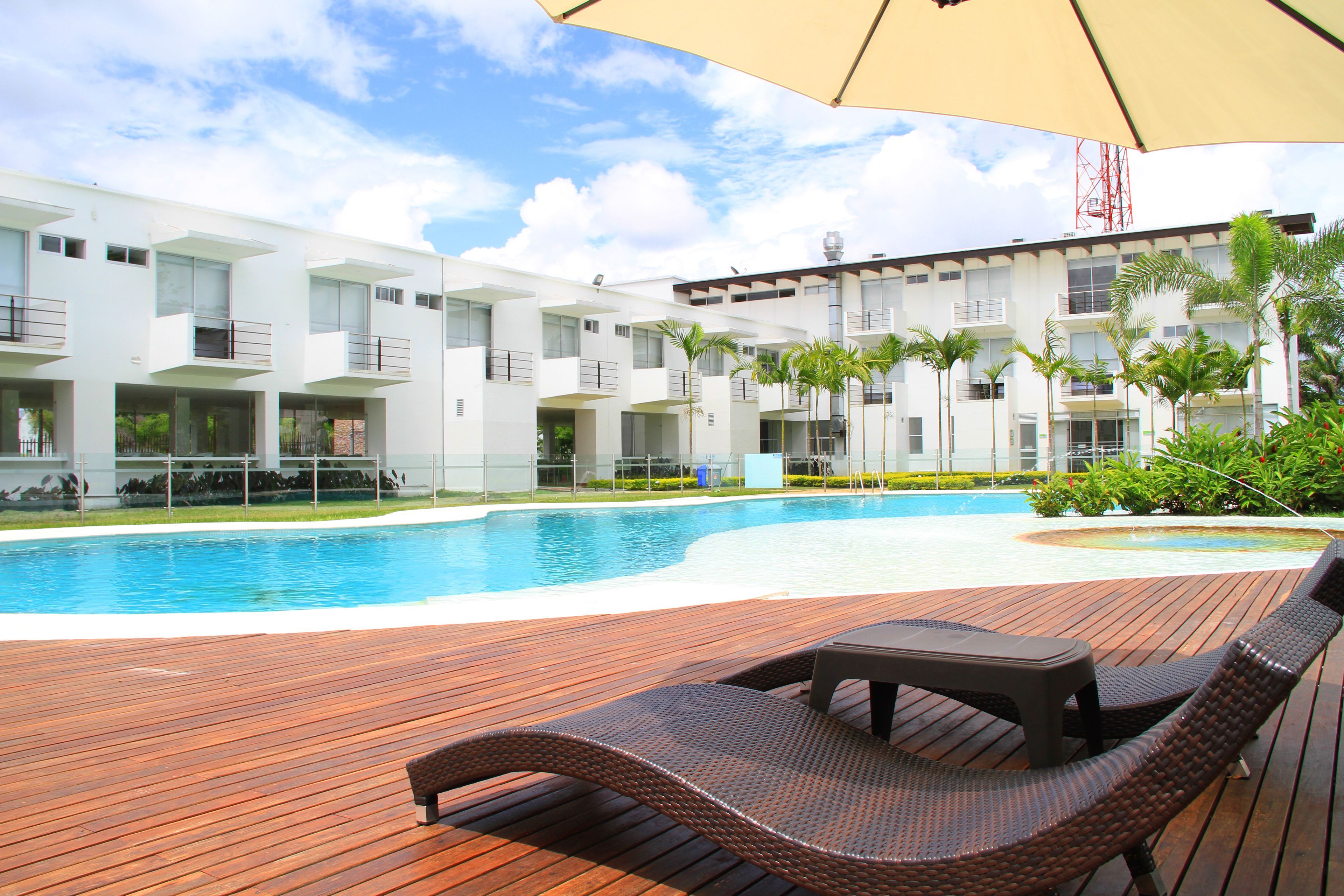 Una piscina al aire libre, sillones reclinables de piscina