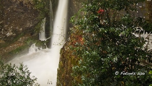 A stone building with a balcony overlooking a waterfall. - Casa Rural Santu Colás (Cangas de Onis)