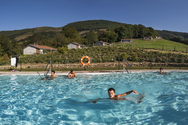 Piscina a l'aire lliure de temporada, para-sols i gandules