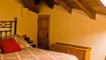 A bedroom with a bed, a wooden door, and a window.