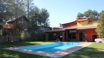 Una casa de dos pisos con piscina en el patio trasero.