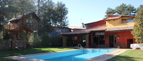 Una casa de dos pisos con piscina en el patio trasero.