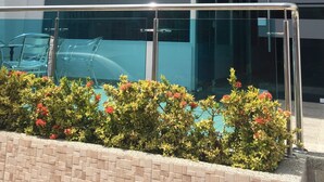 A modern building with a glass facade, a prominent logo, and a sign indicating it is a hotel. - Karin Hotel (Riohacha)