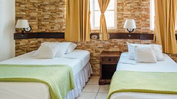 Une chambre d’hôtel avec deux lits, un mur en briques et une fenêtre avec des rideaux.