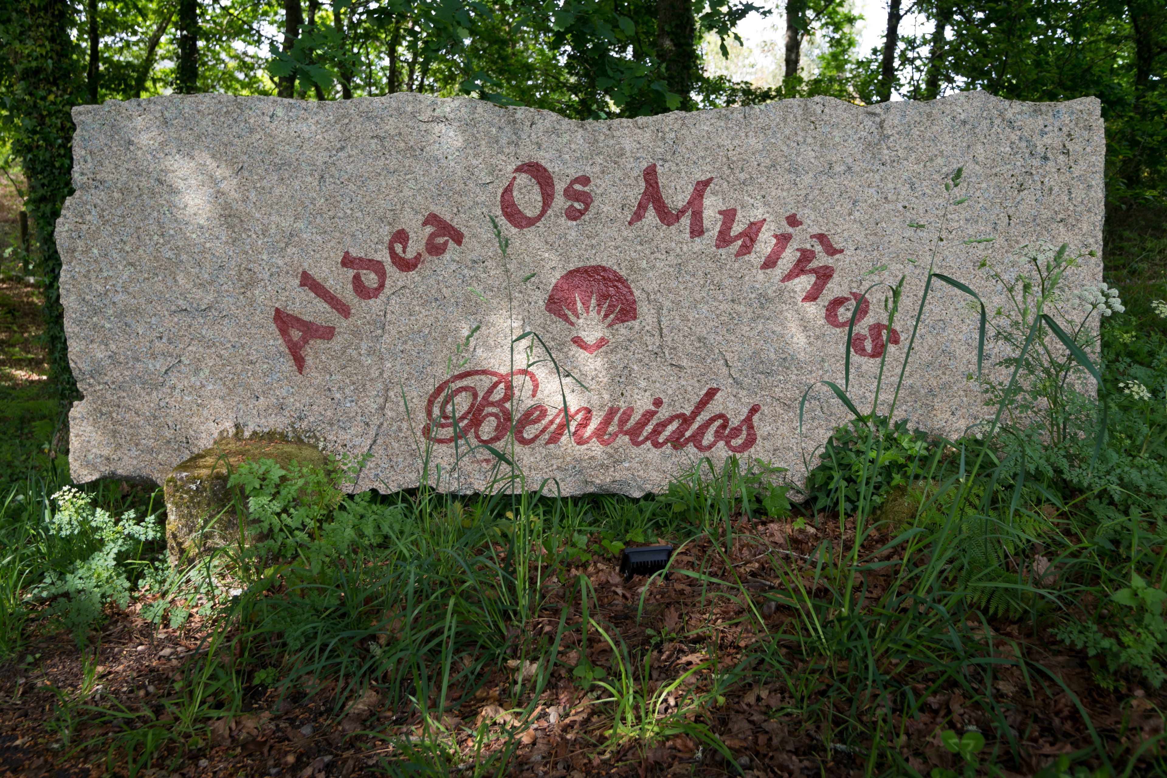 Et stenskilte med teksten "Aloha Os Muituños" og "Berridos" i rød farve.