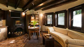 A cozy living room with a sofa, a dining table, and a fireplace.