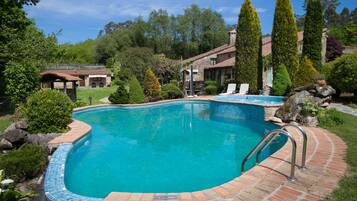 Een seizoensgebonden buitenzwembad, parasols voor strand/zwembad
