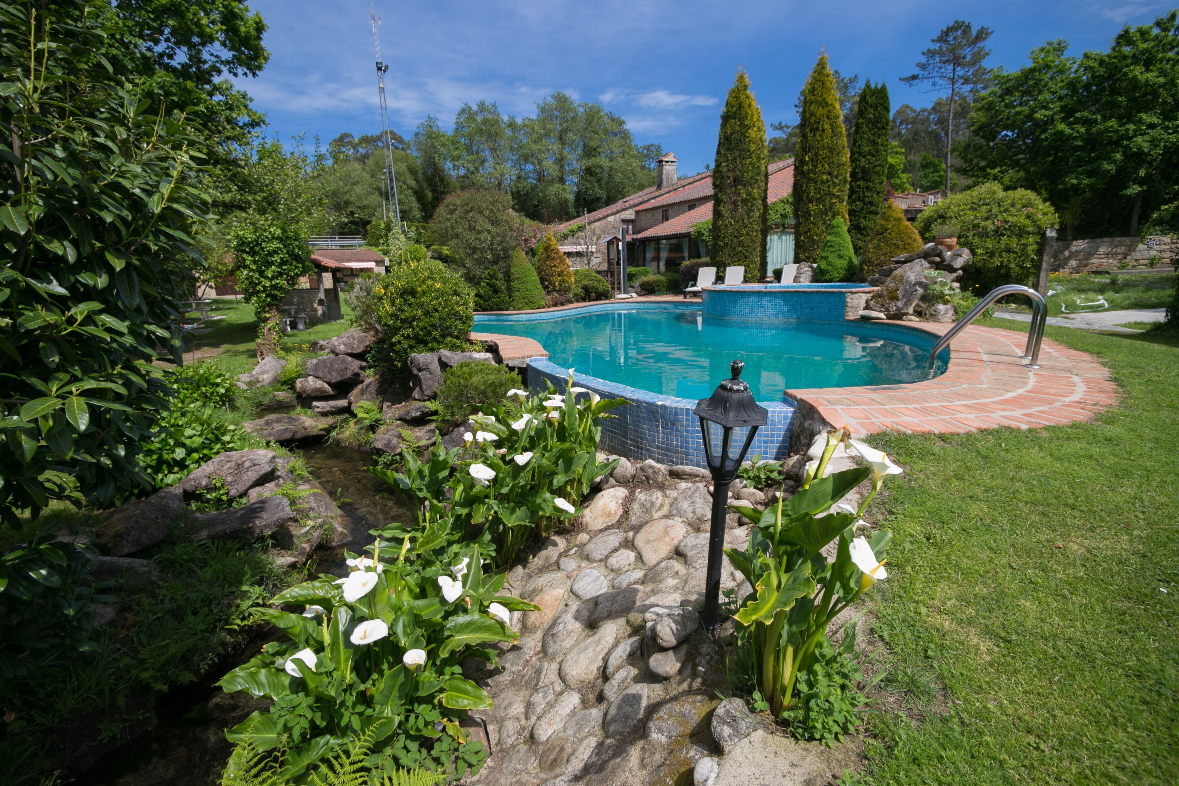 Una piscina al aire libre de temporada, sombrillas, tumbonas