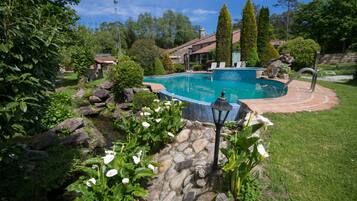 Een seizoensgebonden buitenzwembad, parasols voor strand/zwembad