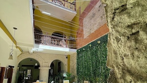 A multi-level interior with a dining area, wooden flooring, and a green wall with plants. - Hotel Casa Tere (Cartagena)