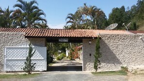 A stone building with a tiled roof, a sign reading "Povoad Vale da Serra," and solar panels on the roof. - Pousada Vale da Serra (Serra Negra)