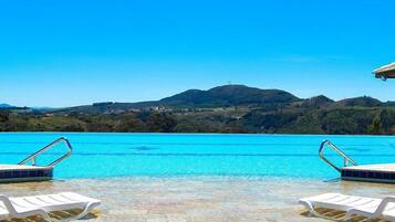 Outdoor pool, an infinity pool, pool umbrellas, sun loungers