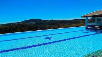 Outdoor pool, an infinity pool, pool umbrellas, sun loungers