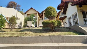A residential area with houses, a small pool, and a clear sky. - Miragem Chales (Serra Negra)