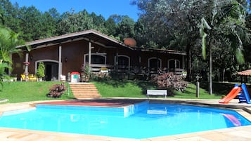 Una piscina al aire libre, sillones reclinables de piscina