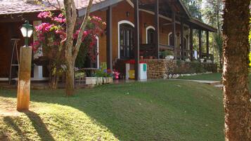 Um edifício com telhado de cerâmica, varanda coberta e gramado bem cuidado.