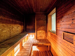 A wooden cabin interior with a wooden bench and a window. - Sounkaku  (Kamikawa)