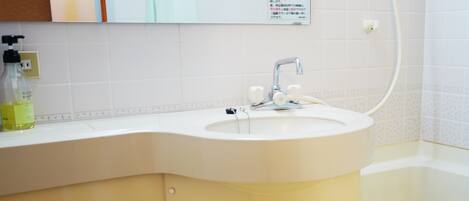 A bathroom with a white sink, a mirror, and a towel rack.