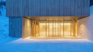 A modern building with a wooden facade and a well-lit entrance. - Sounkaku  (Kamikawa)
