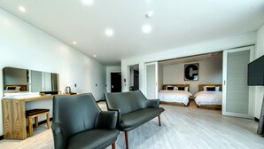 Una habitación de hotel moderna con un sofá, un escritorio y dos camas.