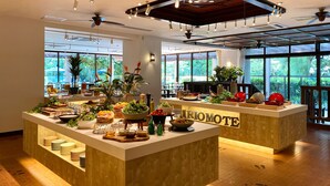 A well-lit indoor space with a reception desk, large windows, ceiling fans, and various plants. - Iriomote Hotel by Hoshino Resorts (Taketomi)