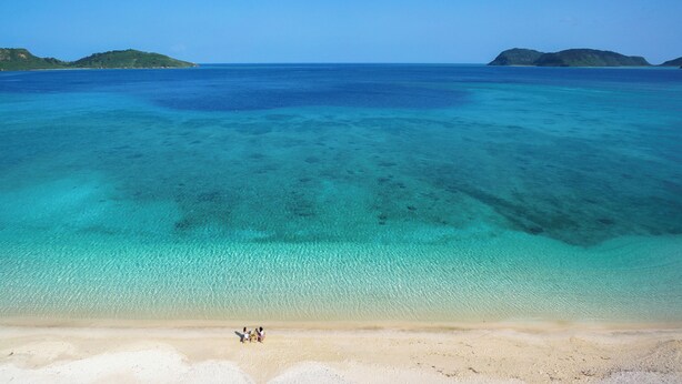 A beach with clear turquoise water and distant green hills. - Iriomote Hotel by Hoshino Resorts (Taketomi)