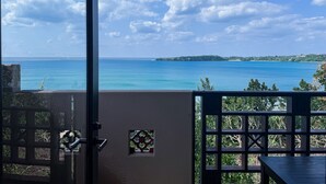 A balcony with a view of the sea and a distant island. - Iriomote Hotel by Hoshino Resorts (Taketomi)