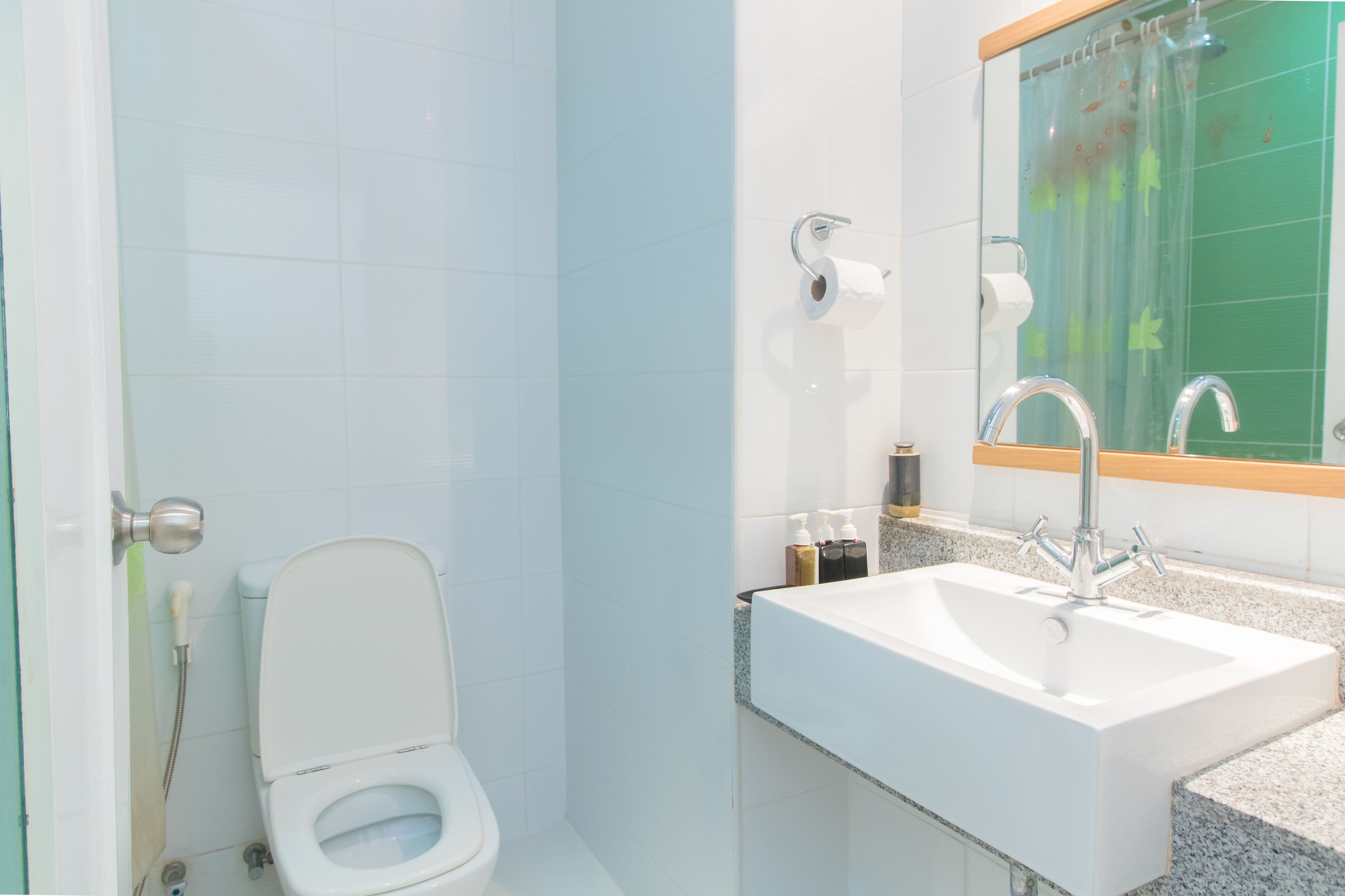 A bathroom with a toilet, sink, and shower.