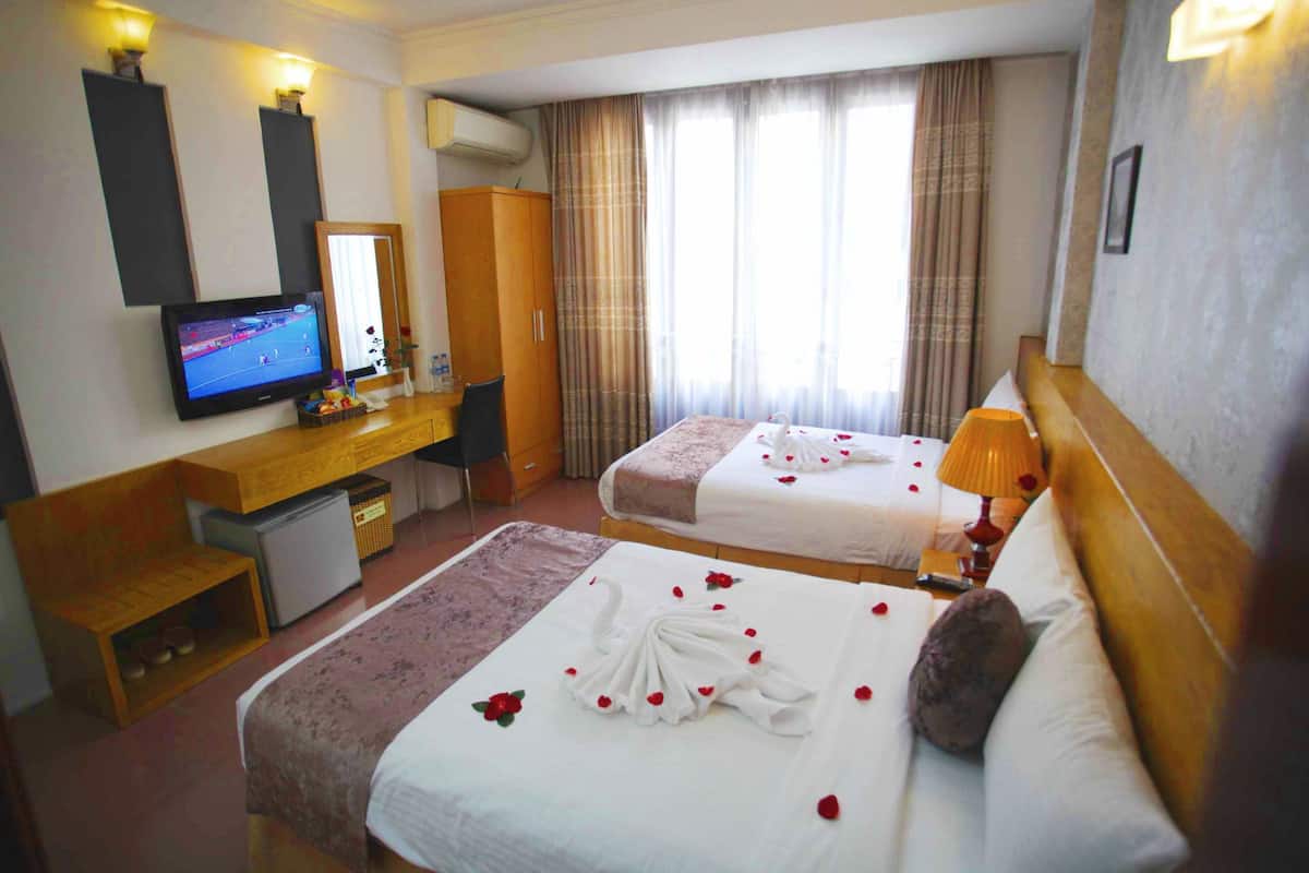Kamar Triple Deluks, pemandangan kota | Minibar, brankas, meja kerja, dan tirai kedap cahaya