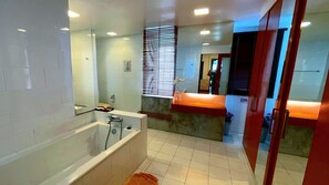 A modern bathroom with a bathtub, a sink, and a mirror. - Beach Gallery House (Pattaya)
