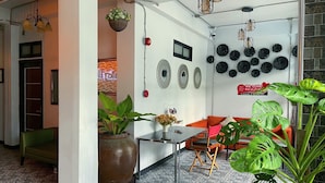 A hotel lobby with a reception desk, seating area, and decorative wall art. - Beach Gallery House (Pattaya)
